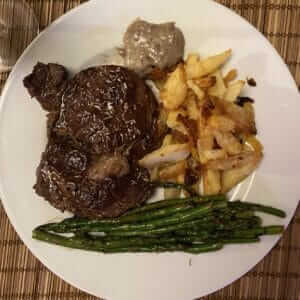 steak dinner with grilled asparagus and oven-baked chips