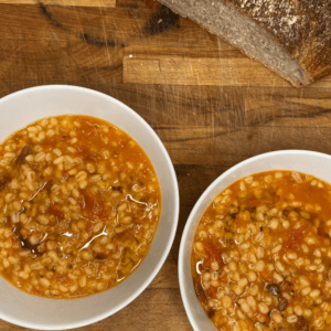 two bowls of barley soup with sourdough bread