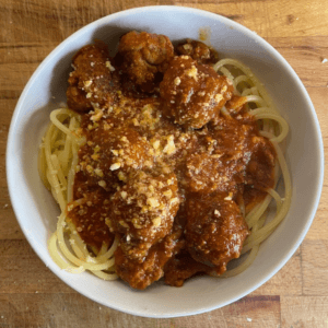 bowl of spaghetti and meatballs with parmesan on top
