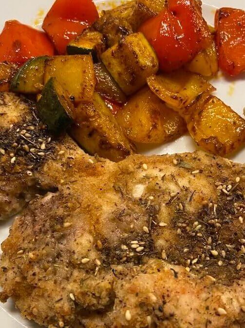 oven-baked chicken breast with za'atar seasoning, accompanied by spiced veggies 