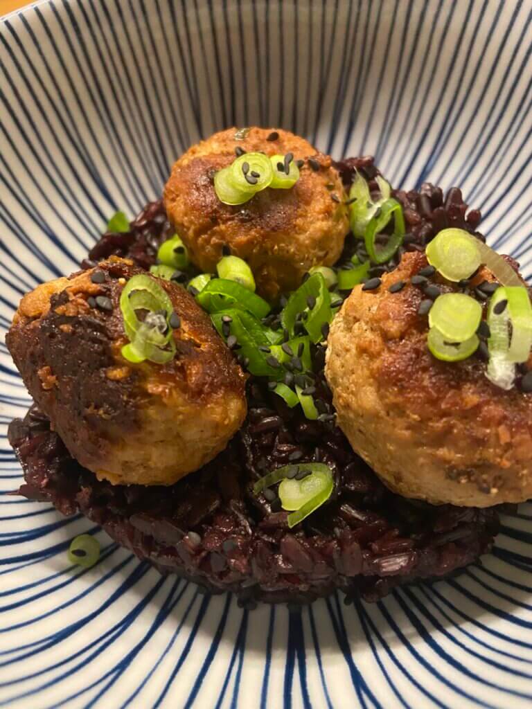 pork meatballs on a bed of black thai rice topped with spring onions